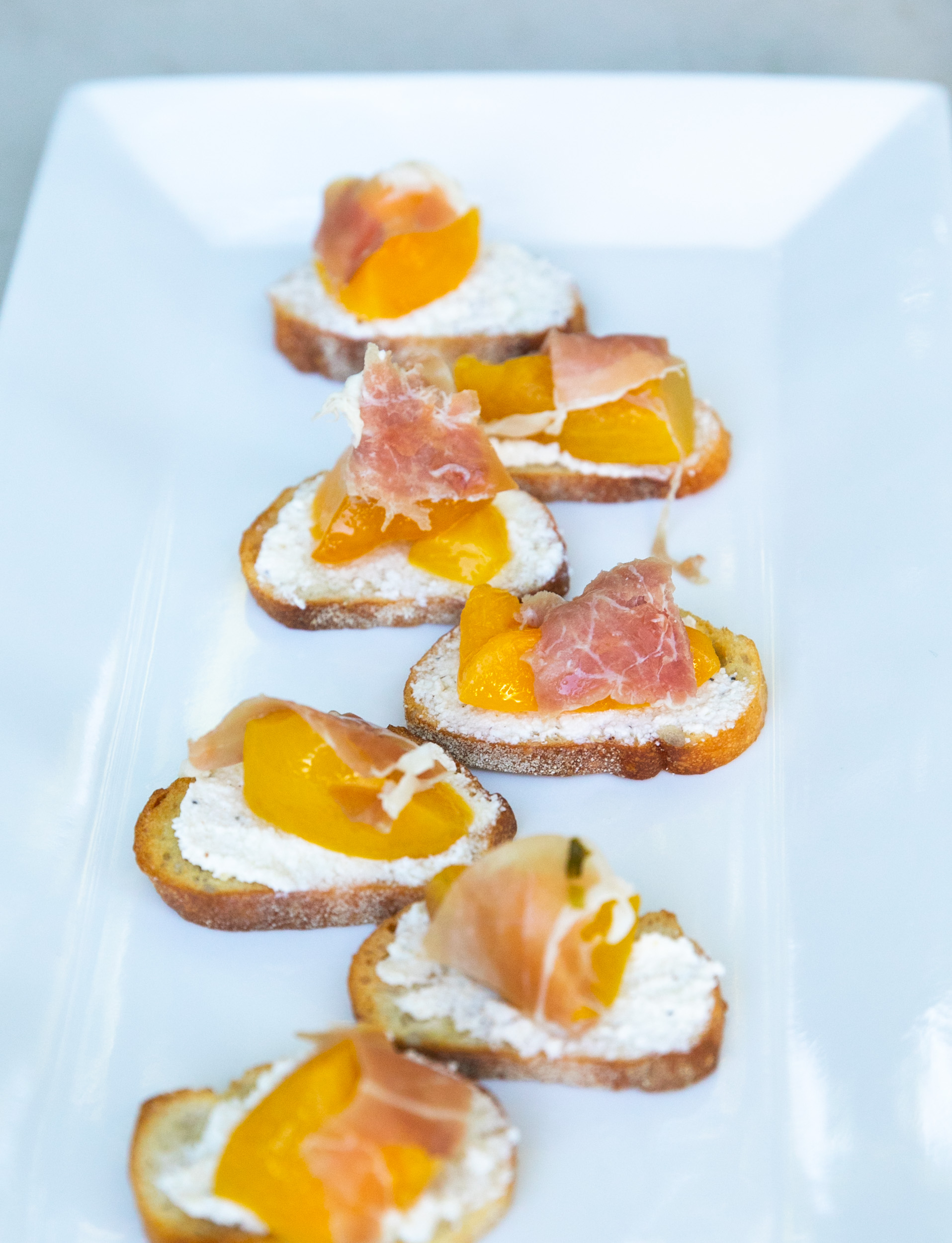 Cocktail hour appetizer Peach and proscuitto crostini served during cocktail hour